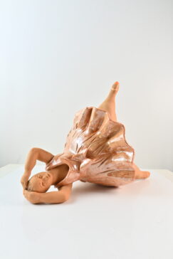 Scultura ballerina in ceramica distesa con abito rosa e una gamba sollevata