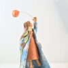 Scultura femminile in ceramica con donna sospesa, mantello azzurro e desiderio